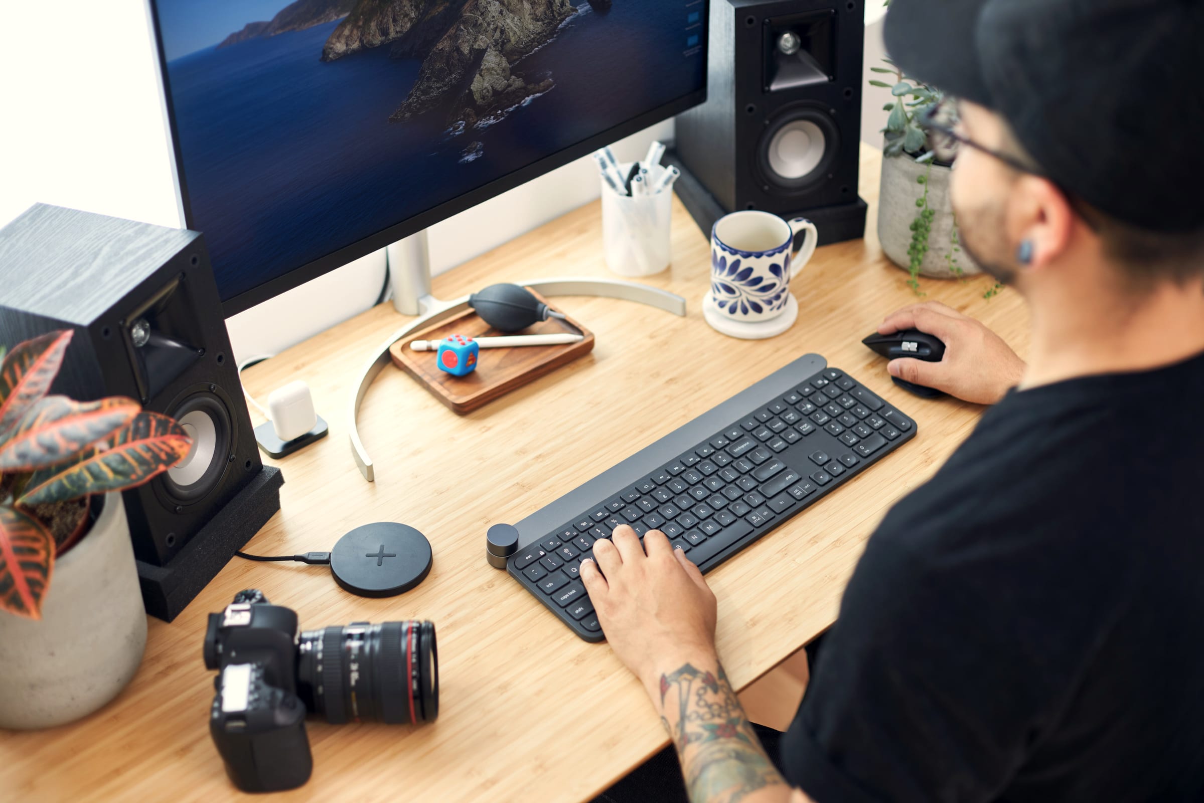 A creative freelancer editing at a desk, camera beside the keyboard.