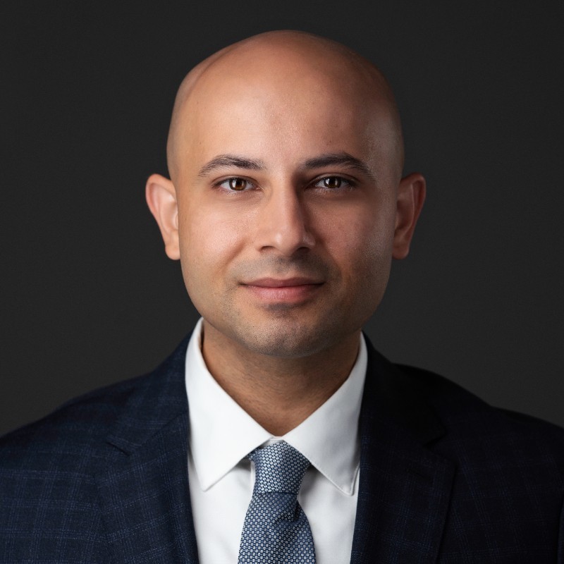 Reuben Mann, founder of MannVenture, in a studio headshot against a dark grey ground.
